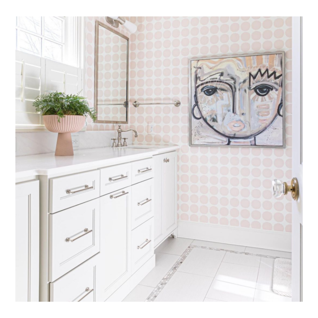Pink and white wallpaper in bathroom with windy oconnor art