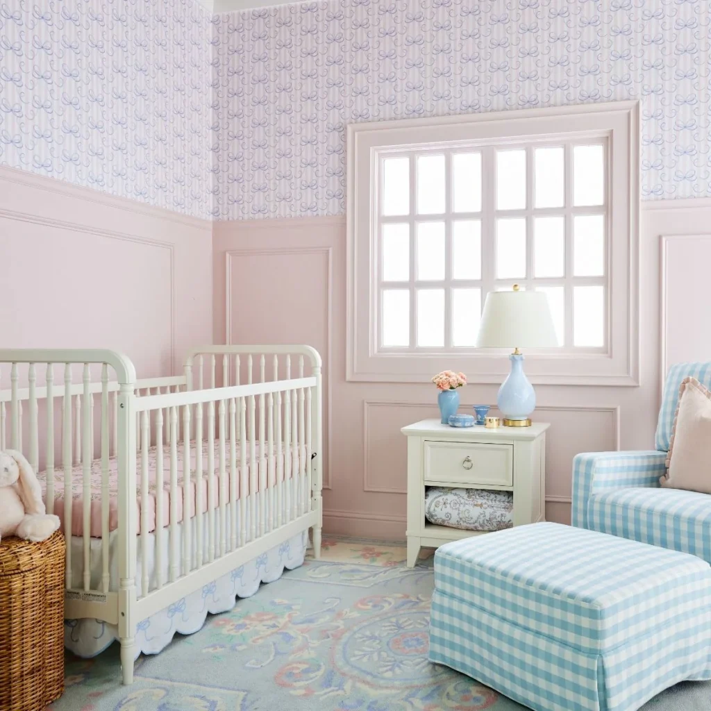 Nursery with pink paneling and bow wallpaper