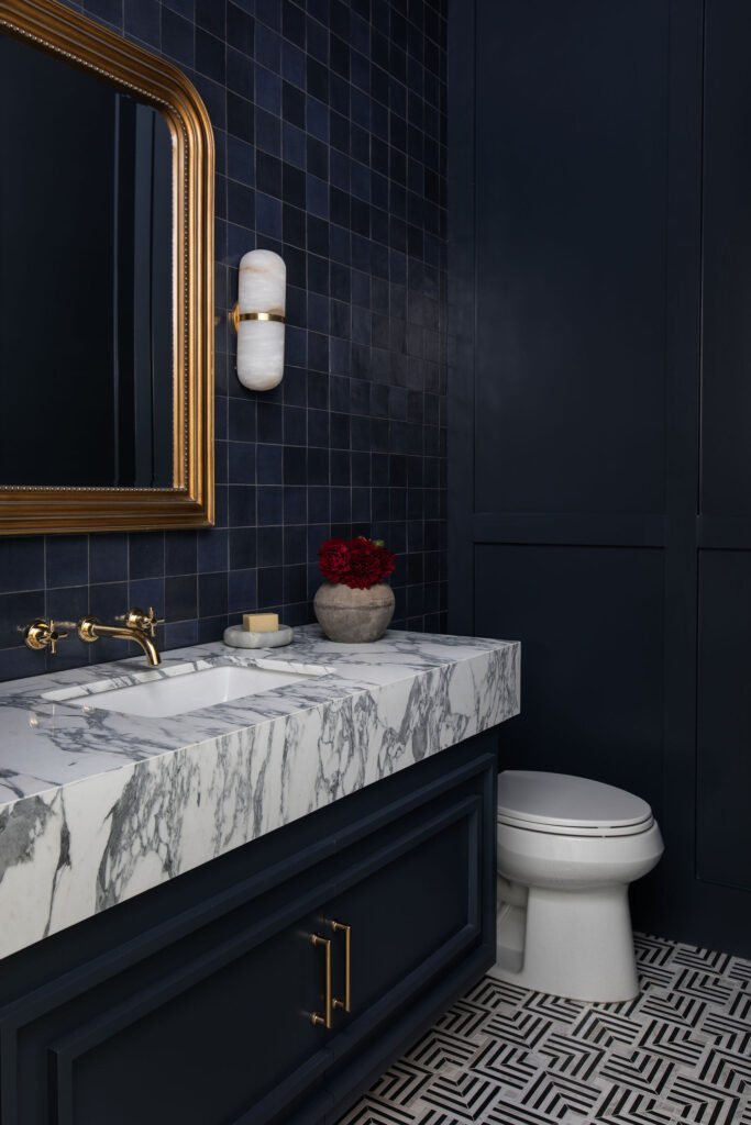 Nuela Designs custom interior design of moody blue powder bathroom with marble