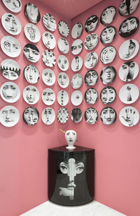 Fornasetti face plates on pink wall display