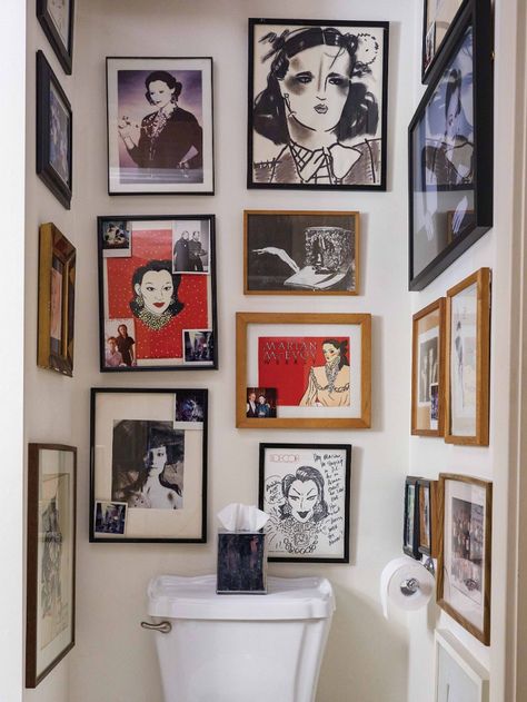 gallery wall of photographs and faces in bathroom